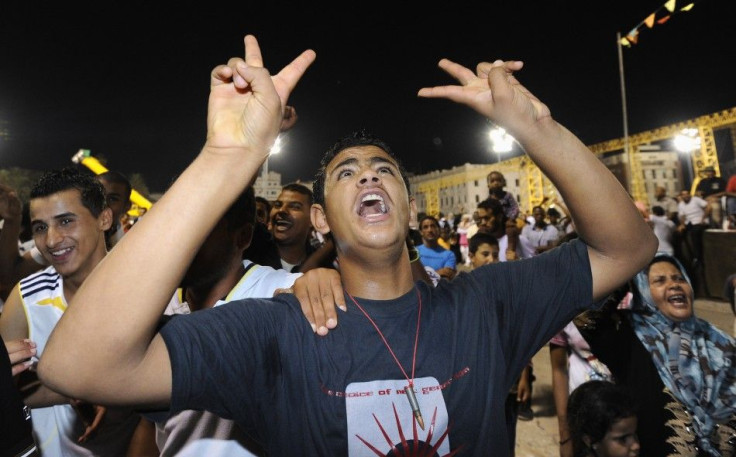 A young man gestures during a pro-Gaddafi rally in Green Square, Tripoli