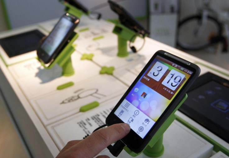 A man plays with a HTC Desire smartphone at a mobile phone shop in Taipei