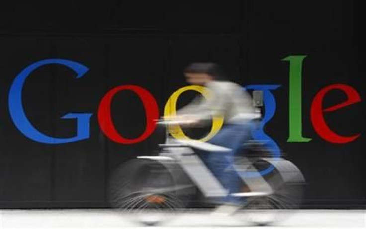 An employee rides her bike past a logo next to the main entrance of the Google building in Zurich