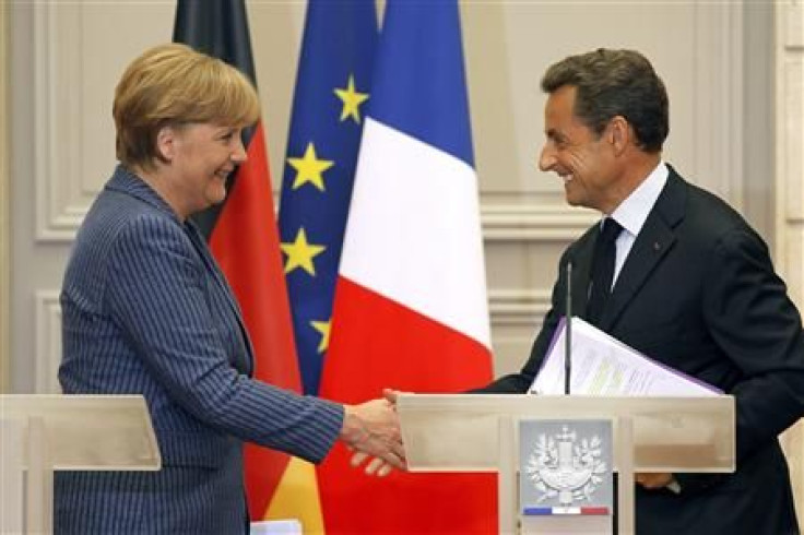 France's President Nicolas Sarkozy (R) shakes hands with German Chancellor Angela Merkel