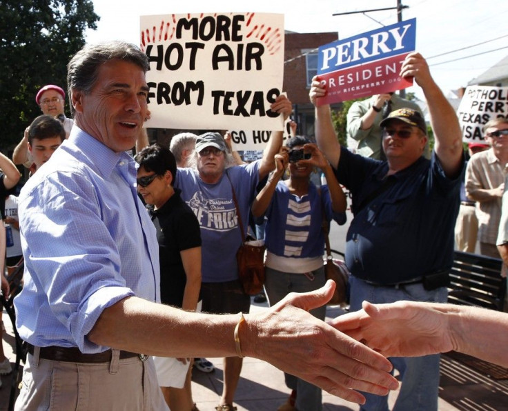 Protestors and supporters of U.S. Republican presidential candidate Texas Governor Rick Perry greet him as he arerives for a campaign stop in Iowa City