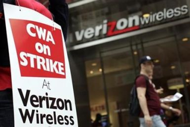 A striking Verizon worker walks the picket line in front of a Verizon wireless store in New York