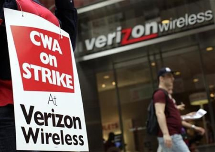 A striking Verizon worker walks the picket line in front of a Verizon wireless store in New York