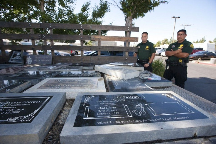 Handout photo shows San Bernardino County Sheriffs deputies looking at headstones recovered during a search of a home in Loma Linda, California