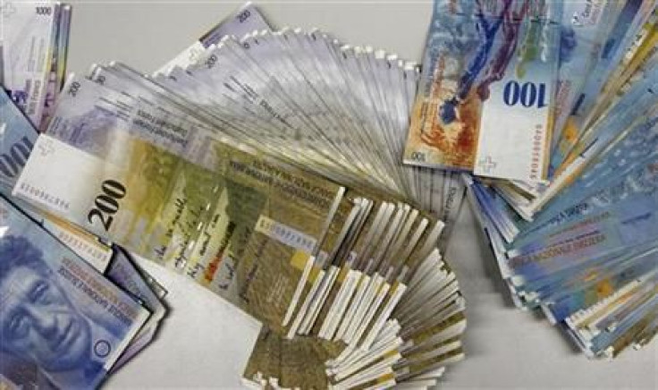 Swiss Franc banknotes of several values lie on a table before being sorted in a money counter in a Bank in Zurich