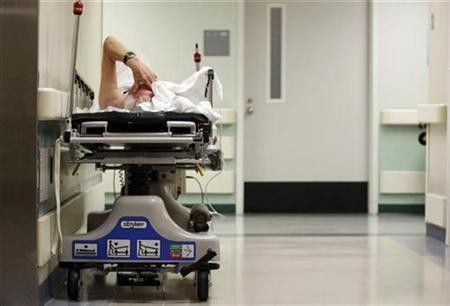 A patient waits in the hallway for a room to open up in the emergency room at a hospital in Houston