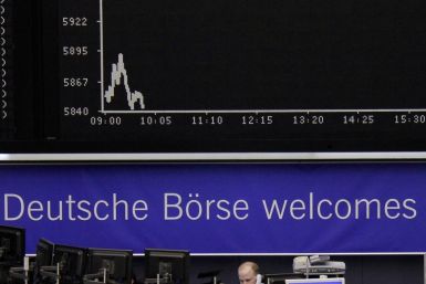 A trader works at his screens in front of the DAX index board at Frankfurt&#039;s stock exchange