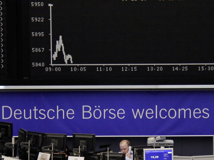 A trader works at his screens in front of the DAX index board at Frankfurt&#039;s stock exchange