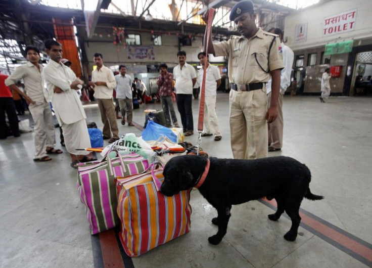 A Railway Protection Force officer uses a sniffer dog to check bags at the Chhatrapati Shivaji railway station in Mumbai