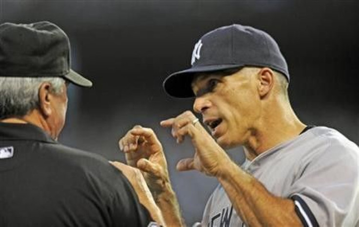 New York Yankees manager Joe Girardi (R) pleads his case with second base umpire Dana DeMuth as he challenges a solo home run by Kansas City Royals designated hitter Billy Butler that hit the railing and bounced back onto the field in the third inning dur