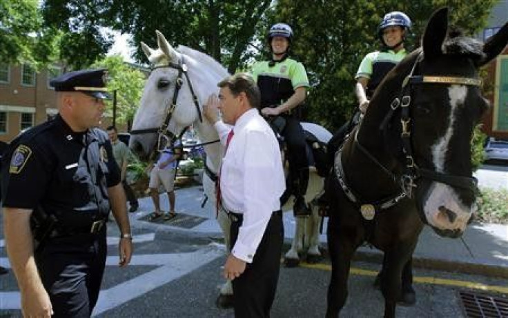 Republican presidential candidate Texas Governor Rick Perry poses for a photograph with members of the local police department after a campaign stop at Harvey&#039;s Bakery and Coffee Shop in Dover, New Hampshire