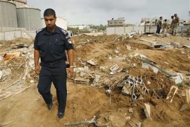 Hamas policeman surveys the damage after Israeli air strikes in the central of Gaza Strip
