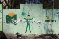 A wall mural depicting Gaddafi government propaganda is pocked with bullet holes after Libyan rebel fighters pushed pro-Gaddafi soldiers out of the center of the strategic coastal city of Zawiyah