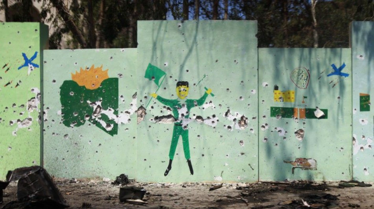 A wall mural depicting Gaddafi government propaganda is pocked with bullet holes after Libyan rebel fighters pushed pro-Gaddafi soldiers out of the center of the strategic coastal city of Zawiyah