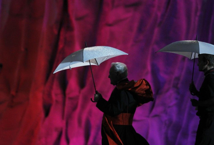 Priests shelter themselves from the rain underneath umbrellas as they leave after a prayer vigil at the Cuatro Vientos aerodrome in Madrid