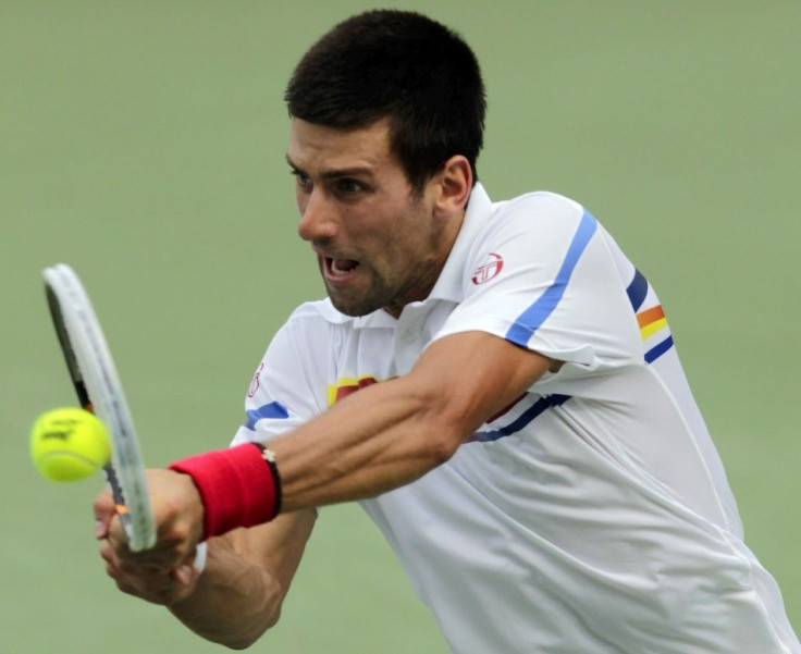 Novak Djokovic of Serbia, hits a return to Tomas Berdych of the Czech Republic, during their semifinal round match of the 2011 Cincinnati Open tennis tournament in Cincinnati