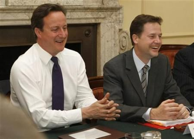 Prime Minister Cameron sits next to Deputy Prime Minister, Clegg, in the Cabinet room in 10 Downing Street in central London