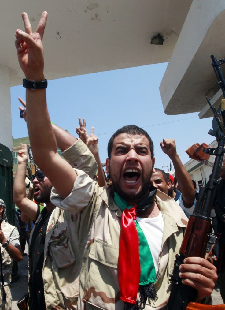 Libyan rebel fighters celebrate after seizing control of the Gaddafi army women&#039;s officer training center in Tripoli&#039;s Qarqarsh district