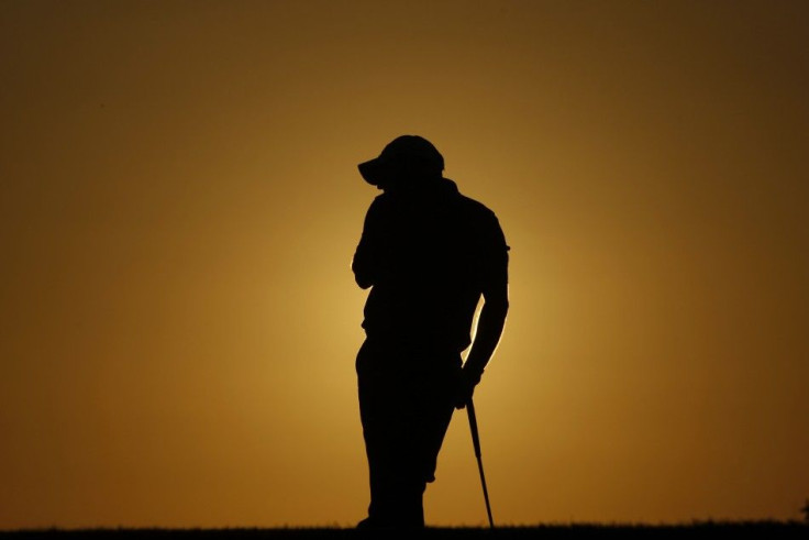 Paul McGinley of Ireland rests on the 18th hole during the first round of the Portugal Master golf tournament