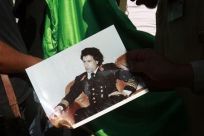 Libyan rebel fighters burn a picture of Muammar Gaddafi at a checkpoint in Tripoli&#039;s Qarqarsh district