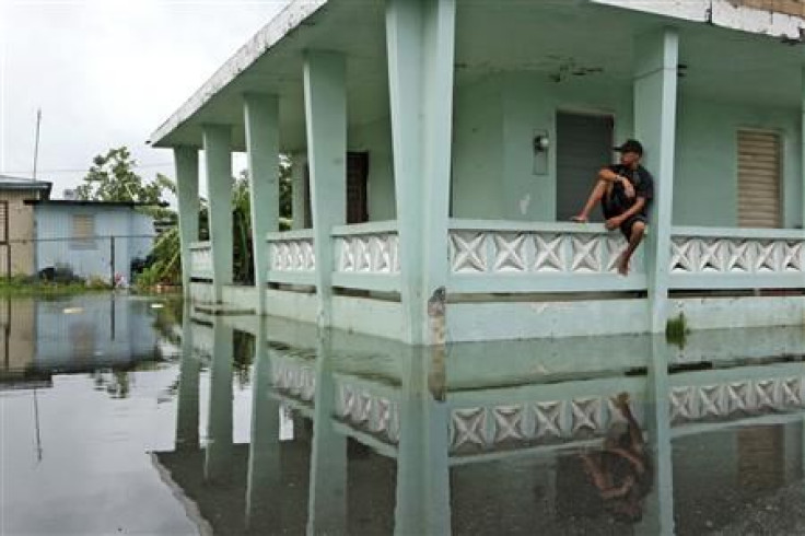 A man sits outside his home after Hurricane Irene hit the municipality of Loiza