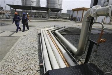 Workers walk past gas pipelines at Ivory coast Electricity Production Company (CIPREL) thermal power station in Abidjan