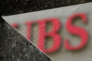 A cobweb is seen in front of the logo of Swiss bank UBS in Zurich