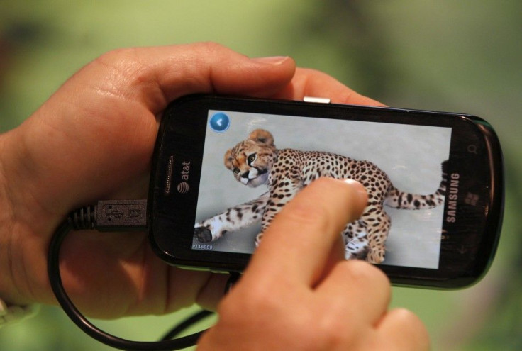 A visitor plays a Microsoft application on a mobile at the Microsoft stand during the Gamescom 2011 fair in Cologne