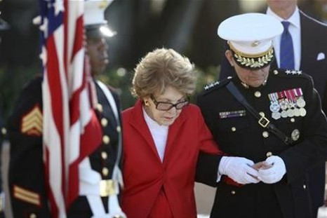 U.S. Marine Corps Lieutenant General George Flynn (R) escorts former U.S First Lady Nancy Reagan after the laying of the wreath ceremony and a 21-gun salute at the resting place of her husband, former U.S. President Ronald Reagan, during his posthumous 10