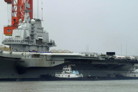Workers are seen on the deck of China's first aircraft carrier, which finished its maiden sea trial and arrived at Dalian Port, Liaoning province