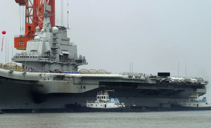 Workers are seen on the deck of China's first aircraft carrier, which finished its maiden sea trial and arrived at Dalian Port, Liaoning province
