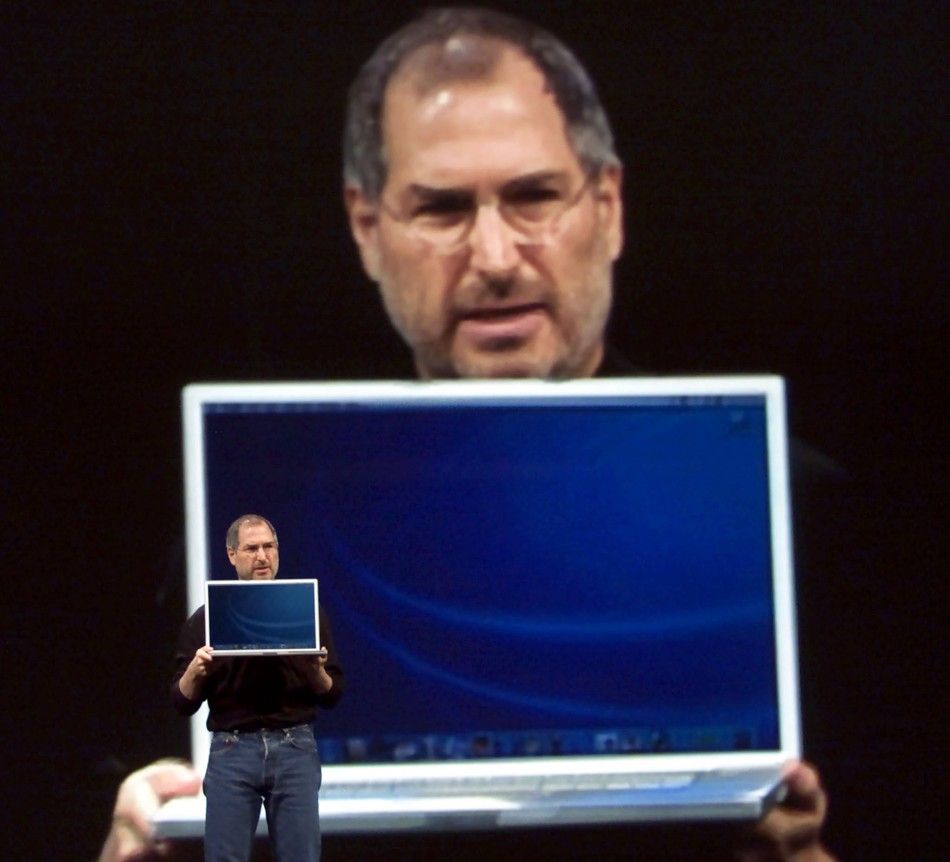 With a giant image of himself projected behind him, Apple Computer CEO Steve Jobs holds a new 17 inch Apple G4 Powerbook laptop computer during his keynote address at the Macworld Conference and Expo in San Francisco