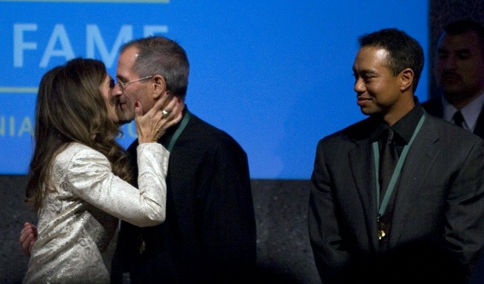 Maria Shriver L kisses Steve Jobs C, chief executive officer of Apple Inc., as golfer Tiger Woods watches after Jobs and Woods were inducted into the California Hall of Fame in Sacramento, California