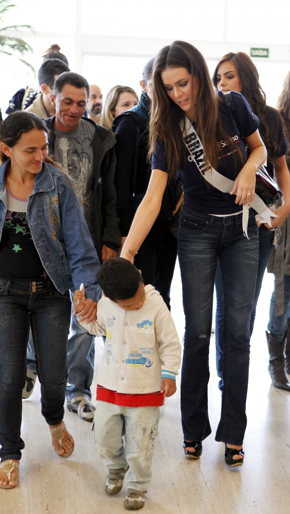 Miss Universe Brazil 2011 Priscila Machado walks with a child with a cleft lip at a hospital during the quotOperation Smilequot event in Sao Paulo