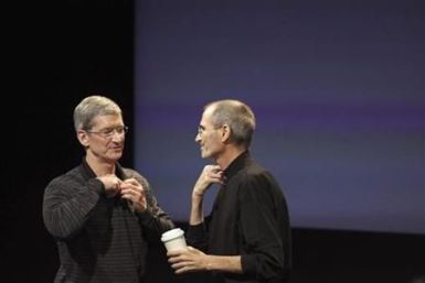 Apple COO Tim Cook and CEO Steve Jobs remove their microphones after a news conference at Apple headquarters in Cupertino