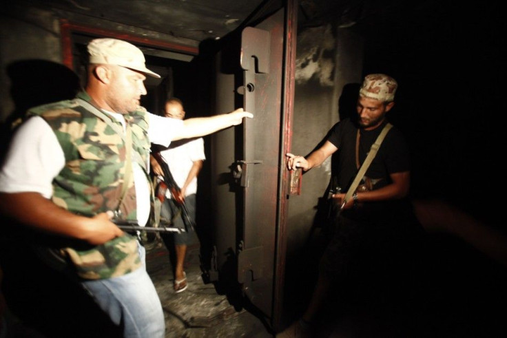 Rebel fighters check an armoured door at a tunnel in the ransacked Bab al-Aziziya compound of ousted Libyan leader Muammar Gaddafi in Tripoli