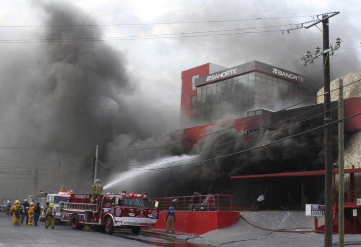 Smoke billows out of a building housing a casino as firefighters try to extinguish the fire after an attack in Monterrey