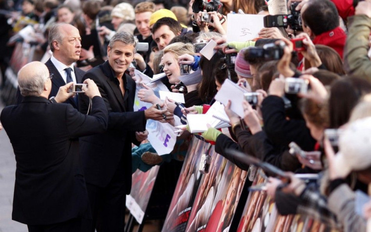 Actor George Clooney signs autographs for fans as he arrives for European premiere of &quot;Leatherheads&quot; at Leicester Square Odeon cinema in London