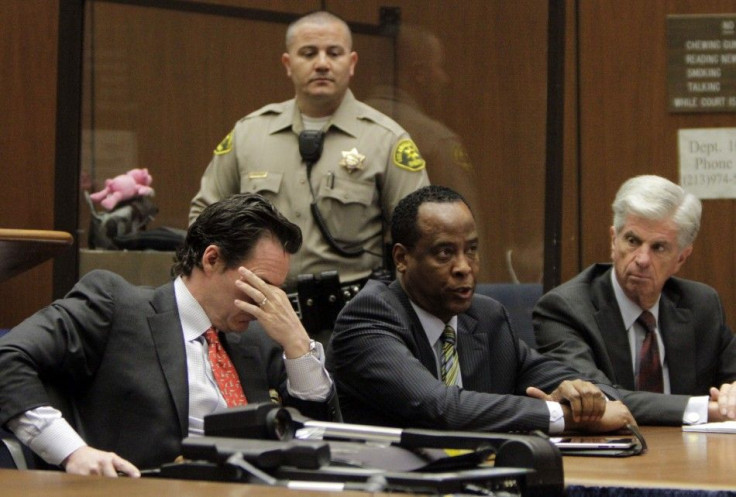 Doctor Conrad Murray sits with his lawyers Edward Chernoff and Michael Flanagan during his arraignment on a charge of involuntary manslaughter in the pop star's death, in Los Angeles
