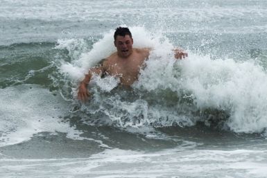 A swimmer braves the shore break as feeder bands from Hurricane Irene begin to pound Atlantic Beach, North Carolina 