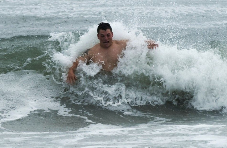 A swimmer braves the shore break as feeder bands from Hurricane Irene begin to pound Atlantic Beach, North Carolina 