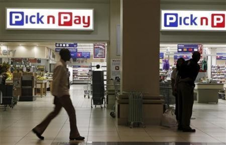 A man (L) walks past a branch of South African retailer Pick n Pay in Johannesburg