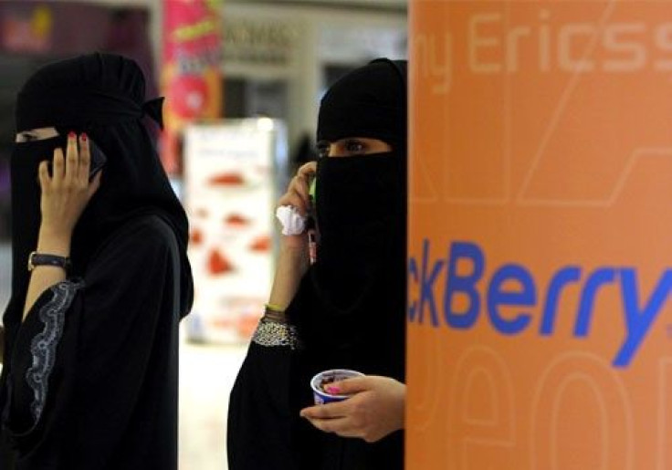 Veiled Saudi women talk on their BlackBerry phones at a shopping mall in Riyadh