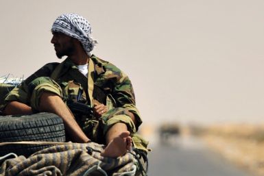 A Libyan rebel is seen near the entrance of Ras Lanuf oil refinery