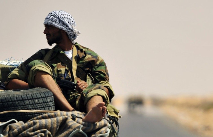 A Libyan rebel is seen near the entrance of Ras Lanuf oil refinery
