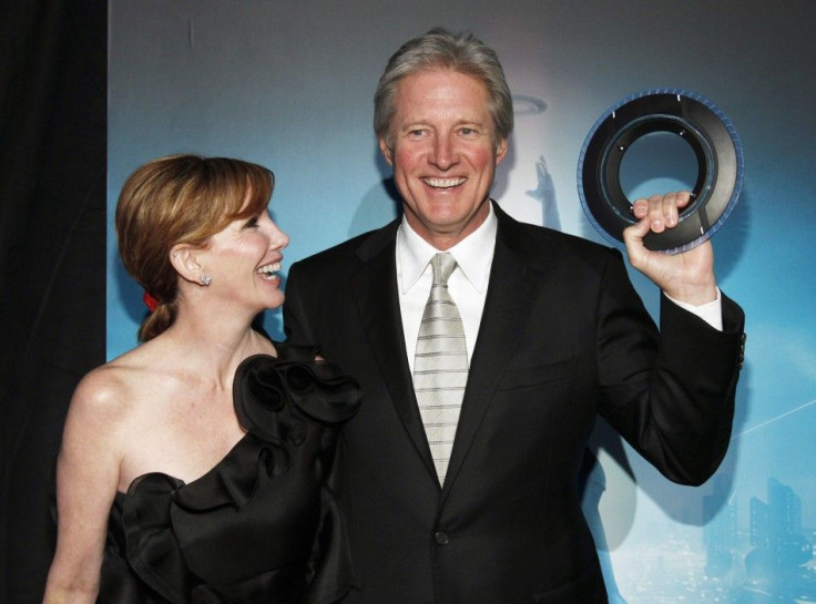 Cast member Boxleitner holds an Identity Disc as he poses with his wife Gilbert at the world premiere of the film &quot;TRON: Legacy&quot; in Hollywood