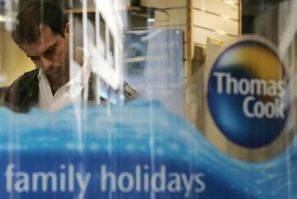 A man looks at a travel brochure of travel company Thomas Cook in London