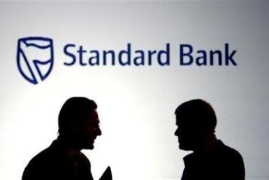 Businessmen chat in front of a Standard Bank logo in Sandton outside Johannesburg