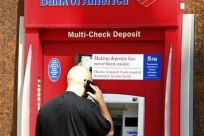 A customer stands at an ATM machine at a Bank of America office in Burbank, California