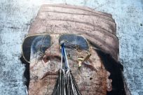 A garbage bag hangs from a portrait of Muammar Gadhafi in Tripoli